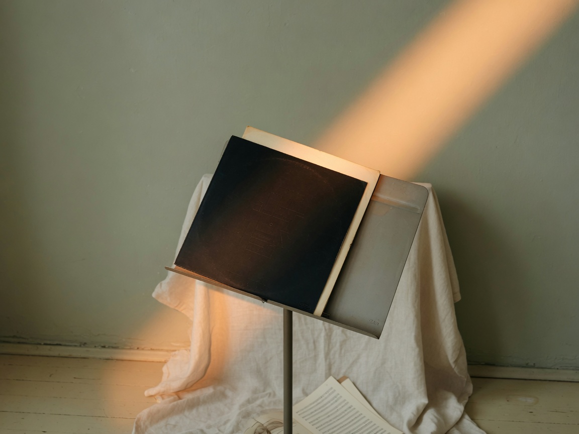 Carátula de vinilo sobre un atril bajo una franja de luz escénica